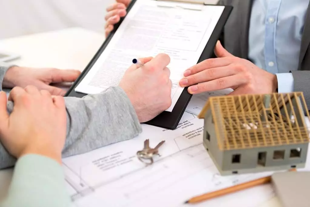 Close up of a couple signing real estate documents